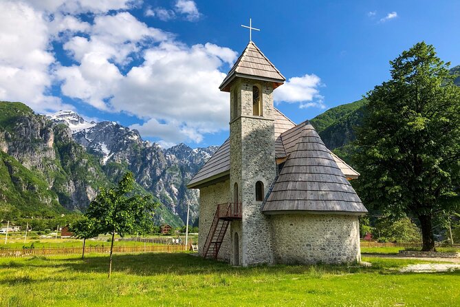 Day Tour of Theth & Hike to Blue Eye from Tirana, Durres/Shkoder - Entering Theth village: church, stone homes, and the Lock-in Tower story